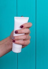 Woman's beautiful hands with care cream tube