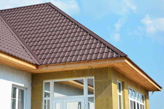 Roofing Construction. House wall repair, renovation, insulation detail. Building insulation exterior, added to buildings for comfort and energy efficiency. Rain Gutter. Soffit and Fascia installation.