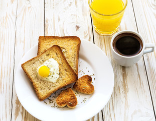 Egg fried in a heart-shaped toast cutout sprinkled