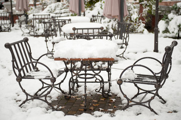 metal table and chairs covered with snow