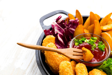 Greasy fried chicken, french fries, ketchup and salad.