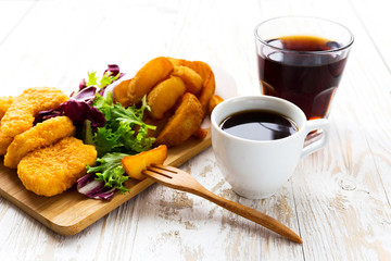 Greasy fried chicken, french fries, ketchup and salad.
