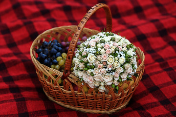 Fototapeta na wymiar boquet and different fruits in wicker basket