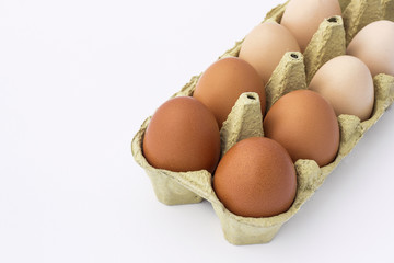 Hen eggs in a paper container isolated on a white background