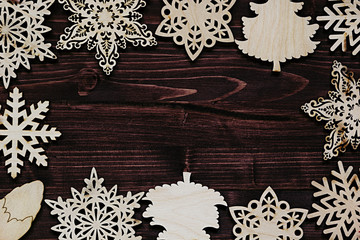Christmas soft beige wooden snowflakes on a vintage wood brown  background. New Year frame background.
