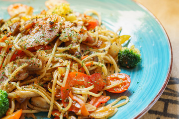 Spaghetti on blue dish with high key.