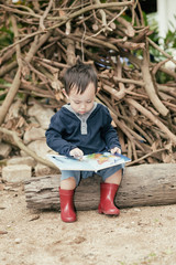 Asian baby boy  reading tale book ,The  Boy wear red boot sittin