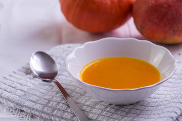 Pumpkin hokkaido soup on white tablecloth.