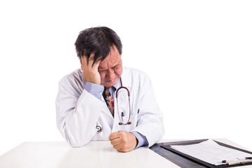 Fototapeta premium Depressed sad matured Asian doctor seated behind desk