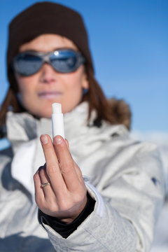 femme en arri&egrave;re-plan avec un stick &agrave; l&egrave;vres &agrave; la neige