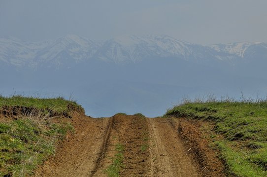 Country road landscape with ATV path crosses the hills