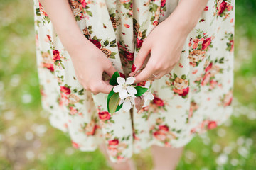 girl in flower dress holding sakura cherry blossom in hands