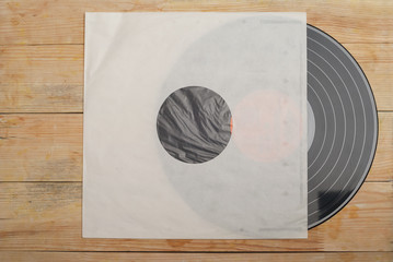 Retro styled image of a collection of old vinyl record lp's with sleeves on a wooden background