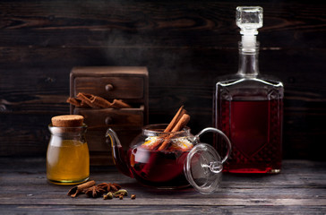 Mulled wine with spices on wooden background