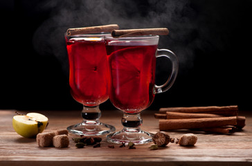 Hot red mulled wine in glasses and spices