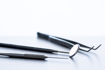 A dentist's tools (mirror, tweezers, probe)