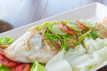 Steamed fish with chili and lemon on wood table , spicy food