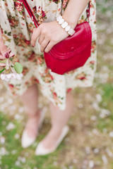 Closeup red bag in hands of woman on the street