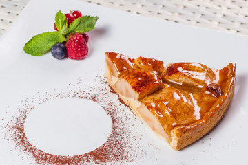apple-caramel cake and berries on a white plate