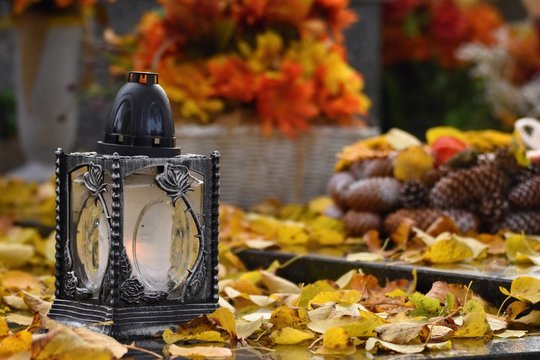 Beautiful autumn concept. Cemetery and Halloween. Candle in a lantern on the grave. Background for Halloween.