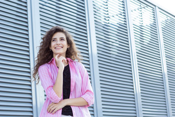 Curly girl laughing outdoors.