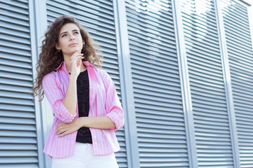 Fototapeta premium Curly girl ponders selection, outdoors