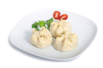 Buryat Manti served on a white plate with tomatoes and herbal on a white background