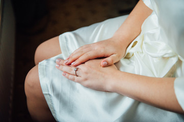 Obraz na płótnie Canvas Tender beautiful bride's hands on white dress
