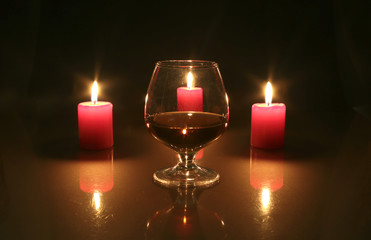 christmas photo cognac glass and candle on black background