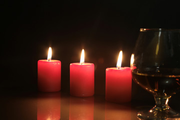 christmas photo cognac glass and candle on black background