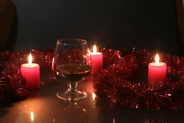 christmas photo cognac glass and candle on black background