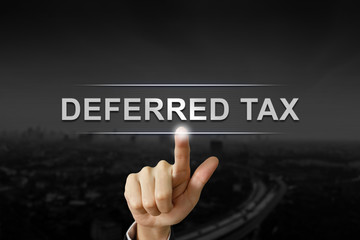 business hand pushing deferred tax button