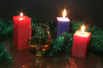 christmas photo cognac glass and candle on black background