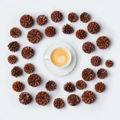 Coffee cup with pine corn on white background. Winter concept. View from above. Flat lay