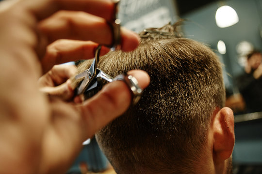 Hand cut with scissors the man in Barbershop closeup