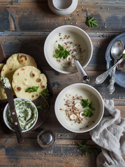 Cauliflower cream soup, corn tortillas and garlic herb butter on a wooden rustic table. Top view © okkijan2010