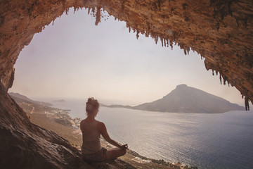 Woman meditating against view of Telendos Island at sunset. Kaly