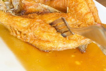close up fried fish with a fork thai food traditional