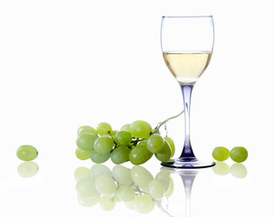 glass of white wine and a branch of grapes on white background