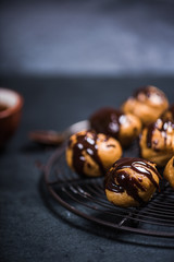profiteroles eclairs resting on cooling rack
