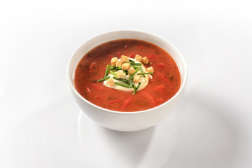 Sweet pepper soup with peppers and sour cream in a white porcela