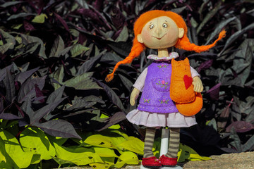 Handmade fabric textile soft doll toy girl in purple violet dress with orange hair and a little red fox in the hands
