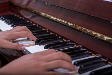 Obraz premium Man playing piano with both hands side view