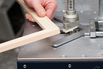 Craftsman working on frame in frame shop. Professional framer hand holding frame angle. Top view.