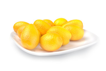 Pile of ripe kumquat on plate over white background