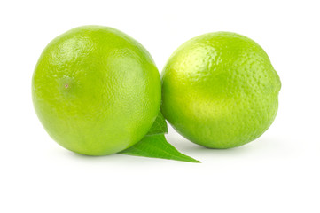 Two whole lime with leaf isolated on white background