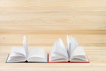 Open hardback books on wooden table. Back to school. Copy space