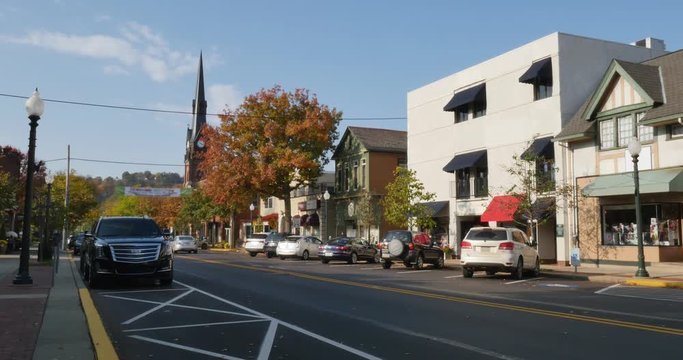 A daytime establishing shot of businesses and a church on a typical Main Street in America. Pittsburgh suburb.	 	