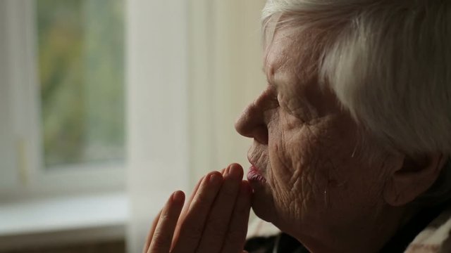 Portrait of elderly praying woman