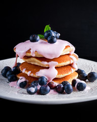 Pancakes with blueberries and yoghurt on white plate
